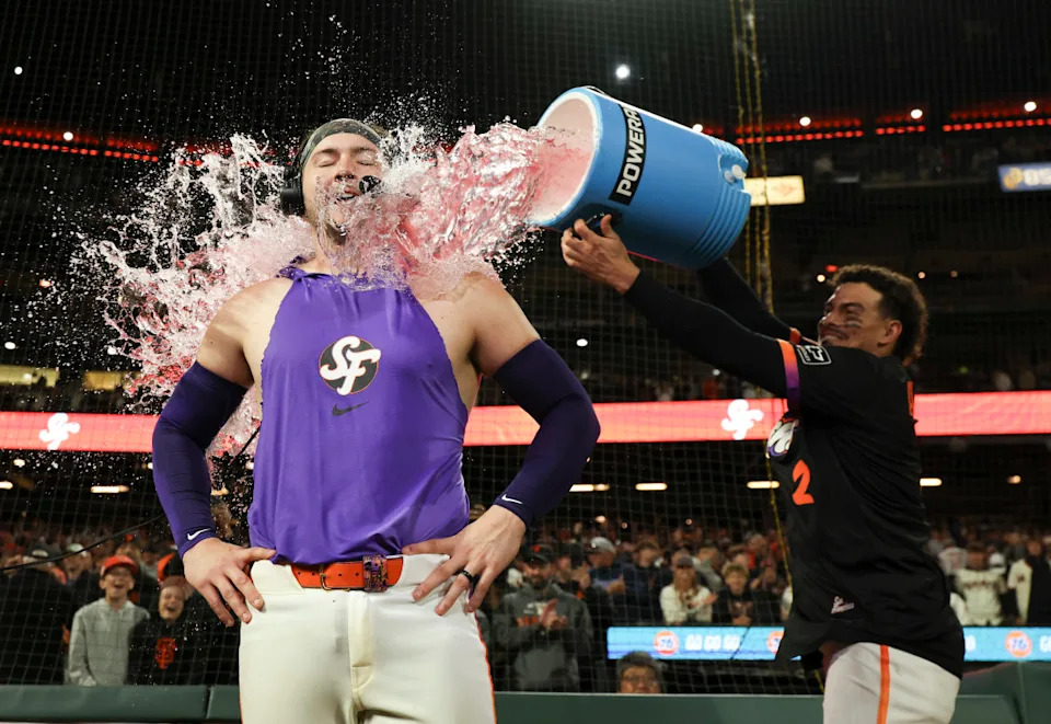 San Francisco Giants shortstop Willy Adames (2) dumps powerade on catcher Patrick Bailey (14) as Bailey is interviewed after hitting a three-run home run during the ninth inning for a walk-off win against the Philadelphia Phillies at Oracle Park. Mandatory Credit: Kelley L Cox-Imagn Images