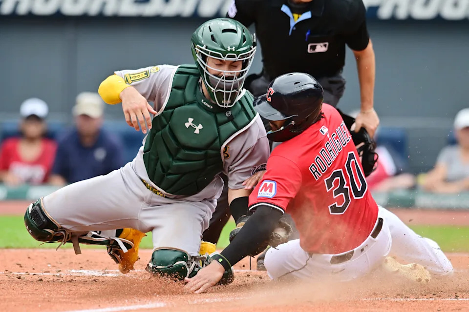 Jul 20, 2025; Cleveland, Ohio, USA; Athletics catcher Shea Langeliers (23) tags out Cleveland Guardians right fielder Johnathan Rodríguez (30) during the fourth inning at Progressive Field. Mandatory Credit: Ken Blaze-Imagn Images