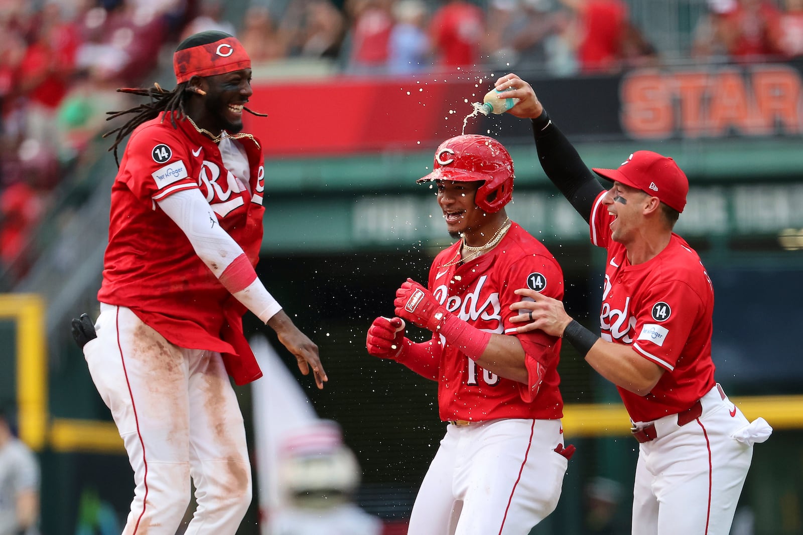 Cincinnati Reds third base Noelvi Marte (16) celebrates his game winning hit in the bottom of the ninth inning with shortstop Elly De La Cruz (44) and first baseman Spencer Steer (7) as part of a baseball game against the Colorado Rockies, Saturday, July 12, 2025, in Cincinnati. (AP Photo/Joe Maiorana)