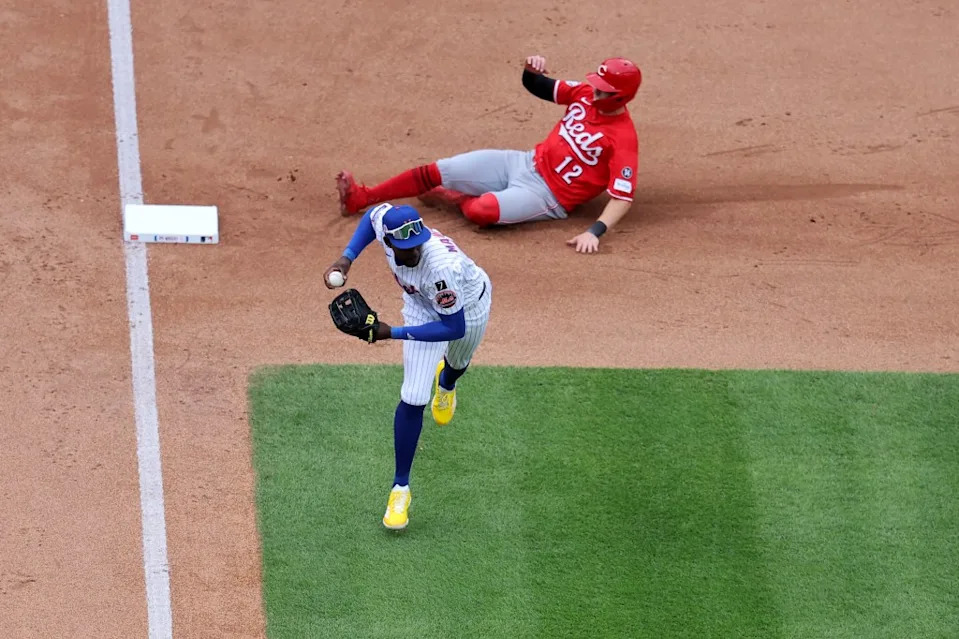 Cincinnati Reds designated hitter Austin Hays (12) slides safely into third base as New York Mets third baseman Ronny Mauricio (10) fields an infield single by first baseman Spencer Steer during the sixth inning at Citi Field. Brad Penner-Imagn Images