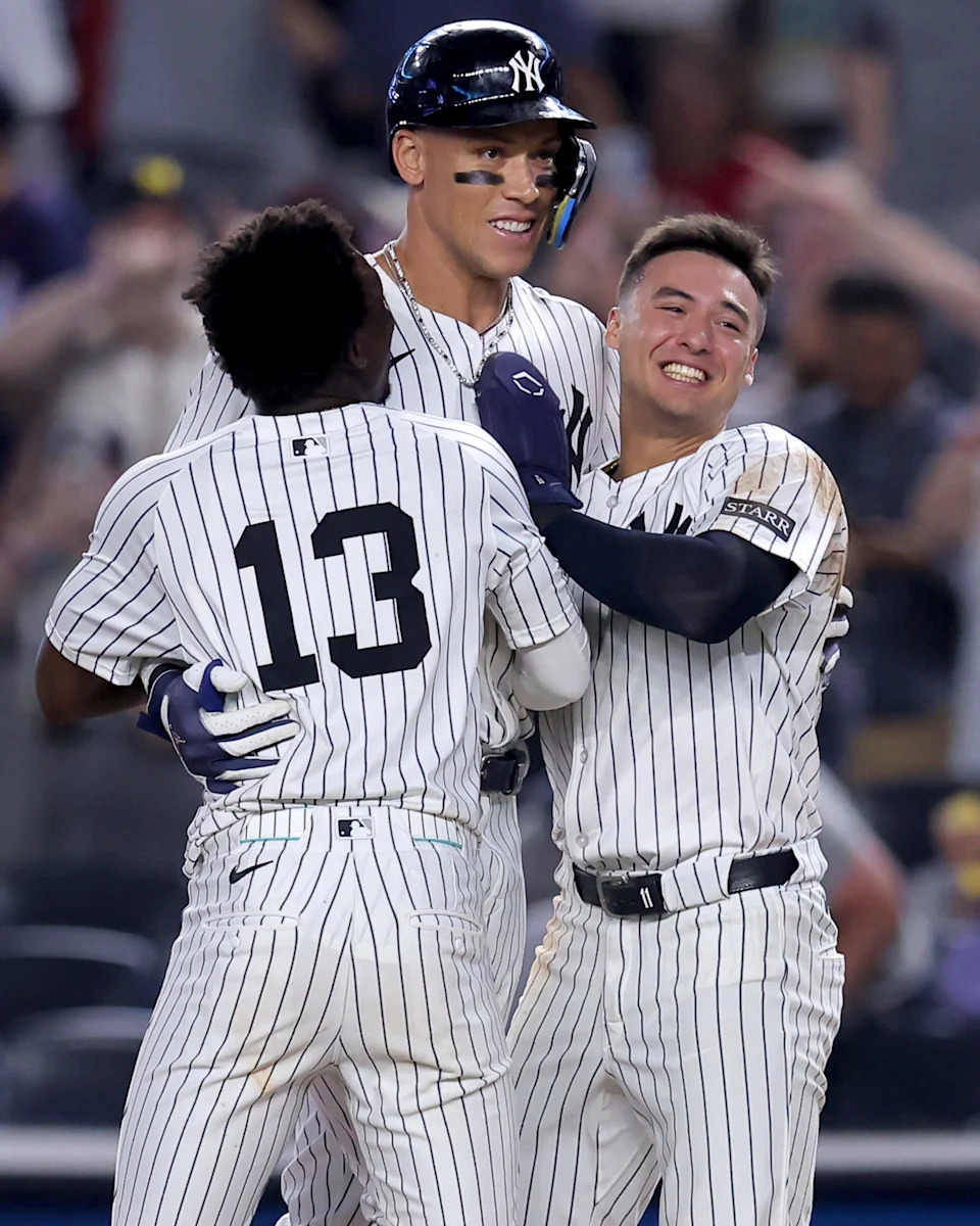Jul 10, 2025; Bronx, New York, USA; New York Yankees designated hitter Aaron Judge (99) celebrates with shortstop Anthony Volpe (11) and second baseman Jazz Chisholm Jr. (13) after his tenth inning walkoff sacrifice fly against the Seattle Mariners at Yankee Stadium. Mandatory Credit: Brad Penner-Imagn Images