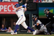 Texas Rangers' Josh Jung, left, follows through on a run-scoring single as Atlanta Braves...