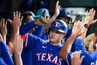 Texas Rangers designated hitter Joc Pederson celebrates with teammates after hitting a...