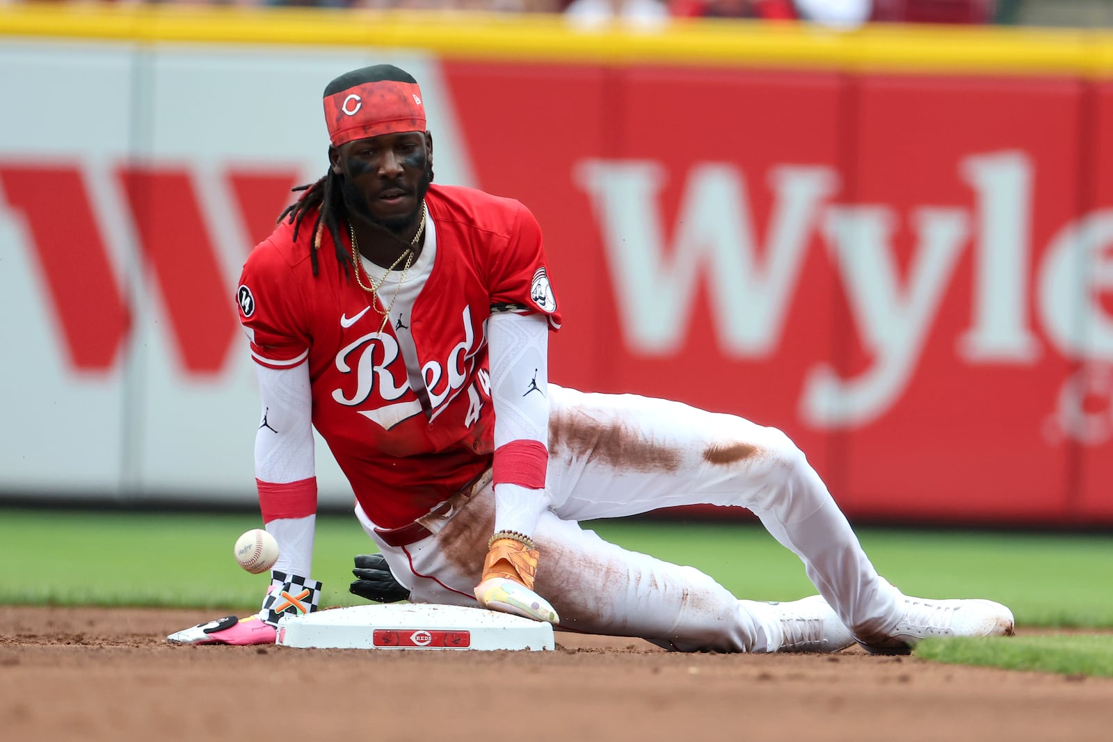 Cincinnati Reds shortstop Elly De La Cruz (44) watches as the ball bounces past on his successful stolen base attempt during the first inning of a baseball game against the Colorado Rockies, Saturday, July 12, 2025, in Cincinnati. (AP Photo/Joe Maiorana)