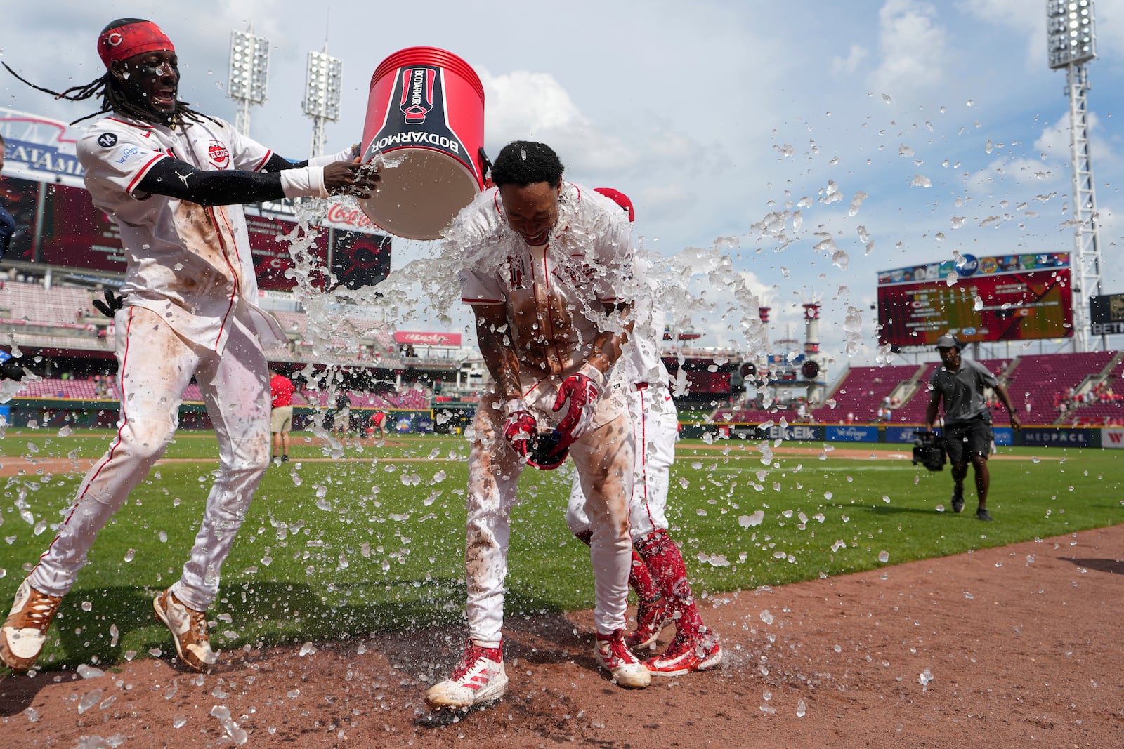 Cincinnati Reds' Will Benson, front right, is doused by Elly De La Cruz , left, and Matt McLain (partially obscured) after hitting a walkoff single in the ninth inning of a baseball game against the San Diego Padres, Sunday, June 29, 2025, in Cincinnati. (AP Photo/Kareem Elgazzar)