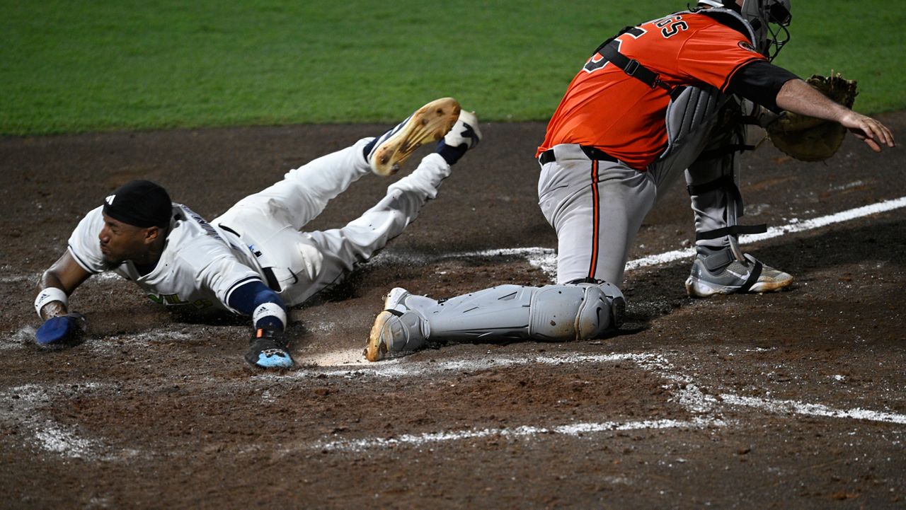 Tampa Bay Rays' Chandler Simpson, left, scores past Baltimore Orioles catcher Jacob Stallings, right, during the eighth inning of a baseball game, Saturday, July 19, 2025, in Tampa, Fla. (AP Photo/Phelan M. Ebenhack)