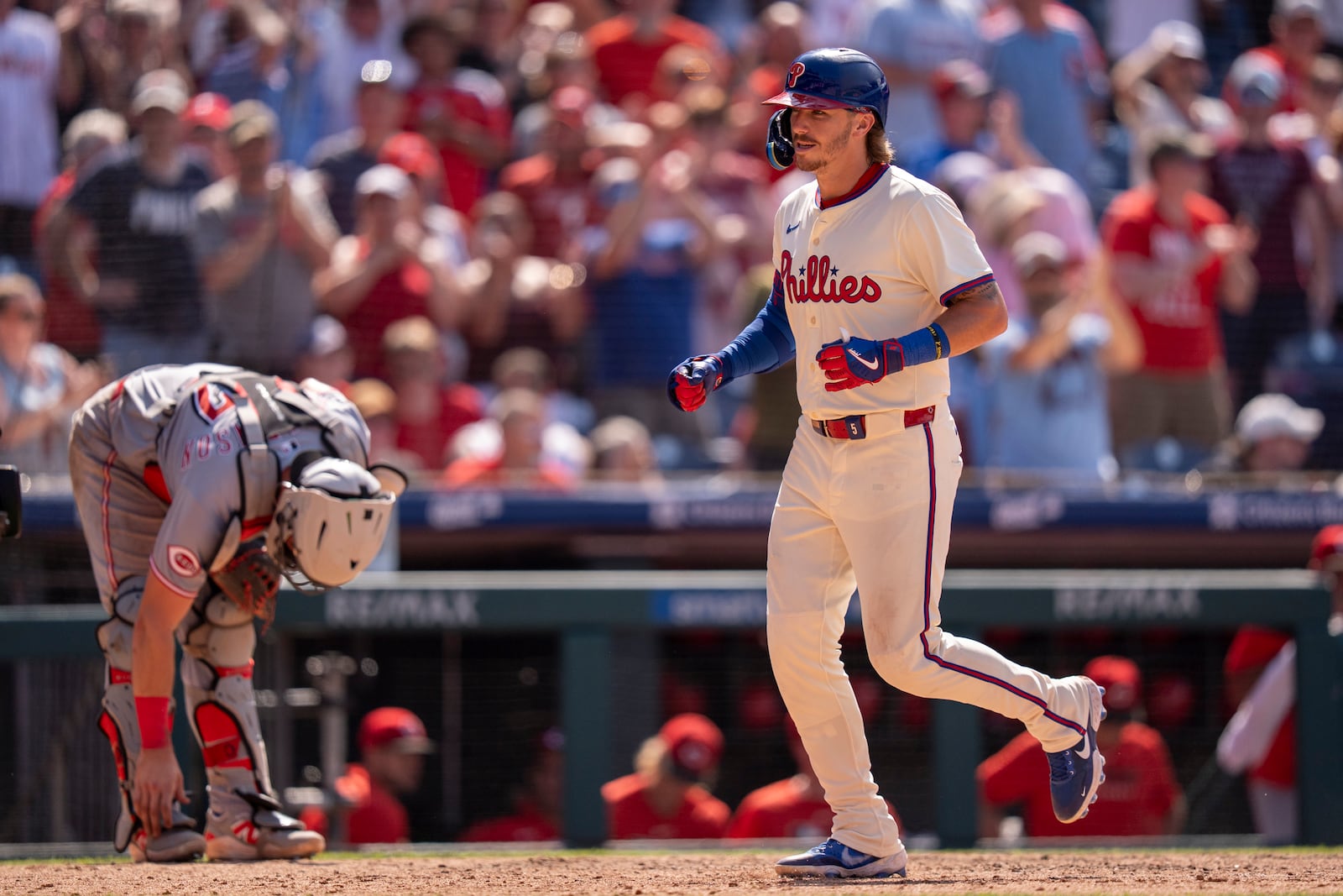 Philadelphia Phillies' Bryson Stott, right, scores on his two-run home run as Cincinnati Reds catcher Tyler Stephenson, left, looks down during the eighth inning of a baseball game, Sunday, July 6, 2025, in Philadelphia. (AP Photo/Chris Szagola)