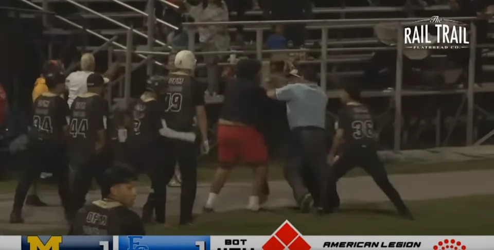 The fan in red shorts is held back. @MyMilfordTV/YouTube