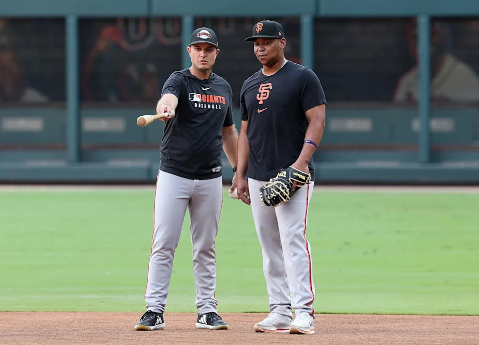 Rafael Devers works with Giants first base coach Mark Hallberg ahead of his debut at first base Tuesday night.
