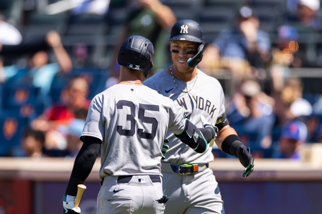 New York Yankees players Cody Bellinger (#35) and Aaron Judge (#99) celebrating a home run.