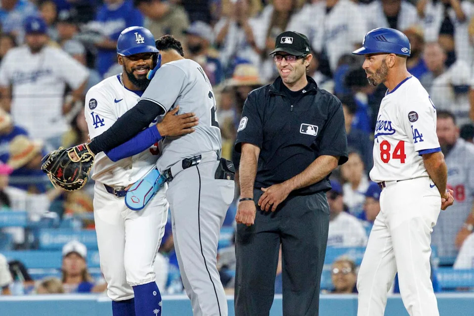 Teoscar Hernandez gets a hug from former Dodger Miguel Vargas after getting hitting his 1,000th career hit.