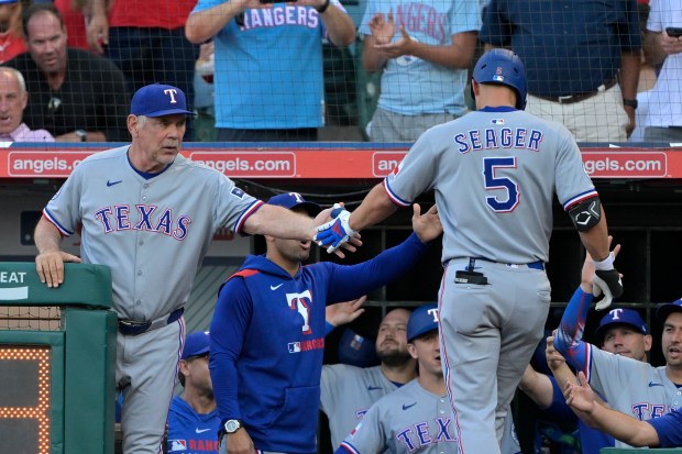 The Texas Rangers’ Corey Seager (5) is greeted by Manager...