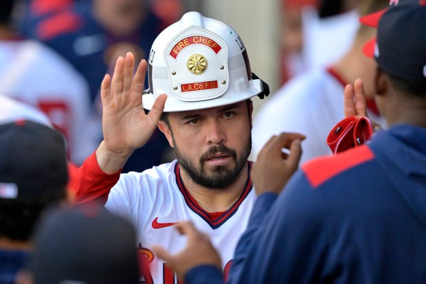 The Angels’ Travis d’Arnaud is congratulated in the dugout after...