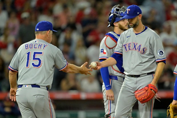 Texas Rangers manager Bruce Bochy, left, takes the ball from...