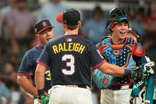 The Seattle Mariners’ Cal Raleigh, watches with his dad Todd...