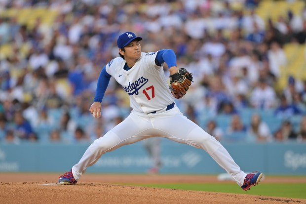 Dodgers starting pitcher Shohei Ohtani throws to the plate during...