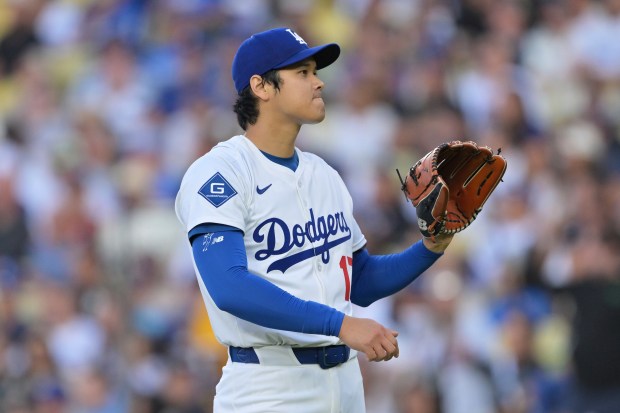 Dodgers starting pitcher Shohei Ohtani reacts as he waits for...