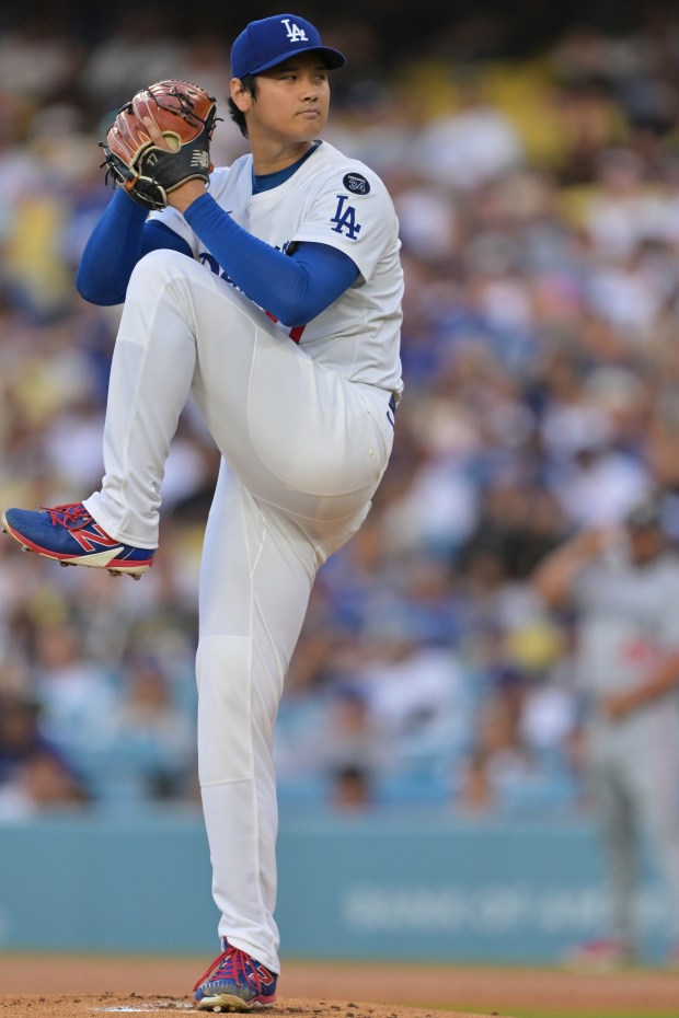 Dodgers starting pitcher Shohei Ohtani throws to the plate during...
