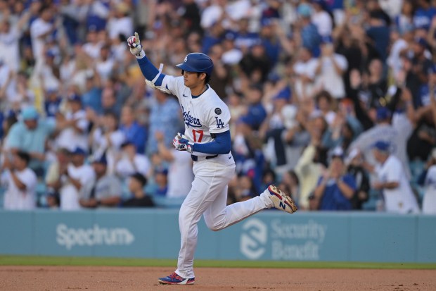 Dodgers star Shohei Ohtani gestures as he runs the bases...