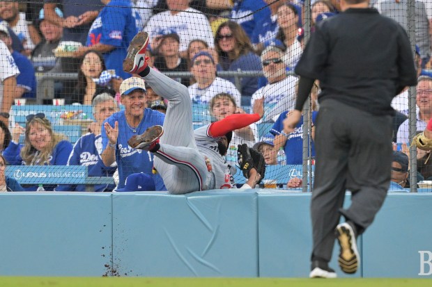 Minnesota Twins second baseman Willi Castro, middle, falls into the...