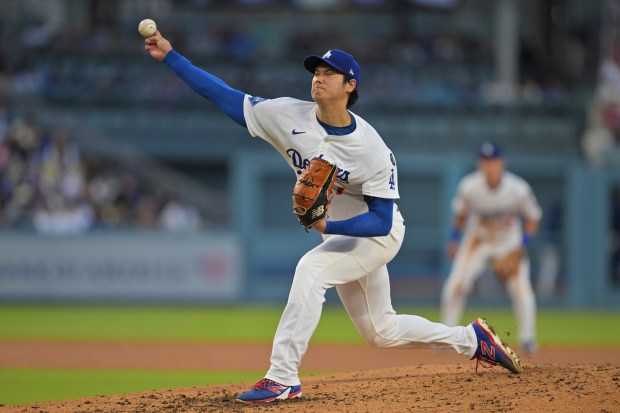 Dodgers starting pitcher Shohei Ohtani throws to the plate during...