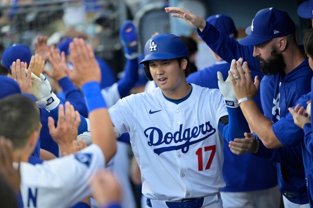 Dodgers star Shohei Ohtani is congratulated by teammates in the...