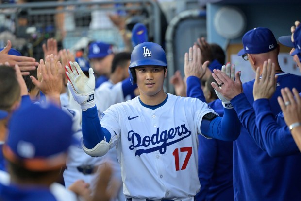 Dodgers star Shohei Ohtani is congratulated by teammates in the...