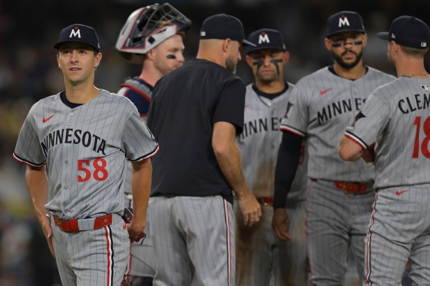 Minnesota Twins starting pitcher David Festa, left, walks off the...