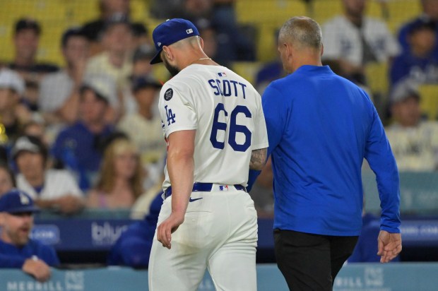 Dodgers relief pitcher Tanner Scott, left, exits the game with...