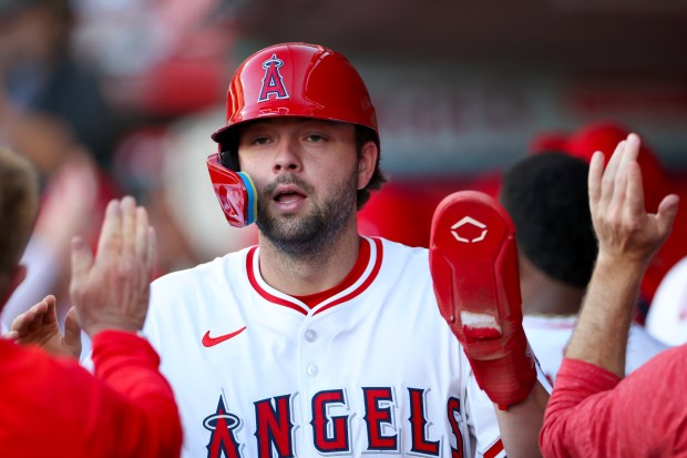 The Angels’ Nolan Schanuel high-fives teammates in the dugout after...