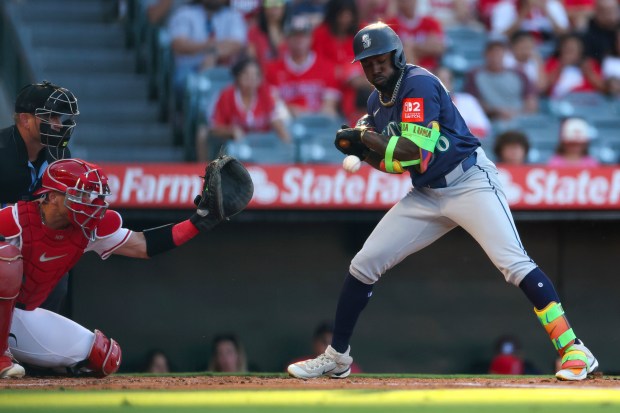 The Seattle Mariners’ Randy Arozarena, right, is hit by a...