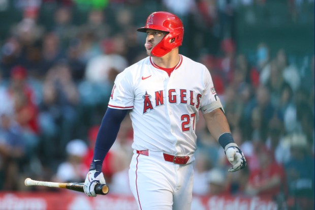 Angels star Mike Trout walks off the field after striking...