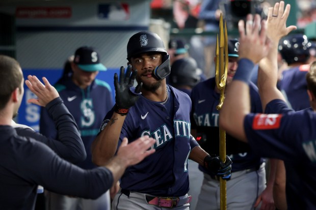 The Seattle Mariners’ Julio Rodriguez, center, celebrates with teammates in...