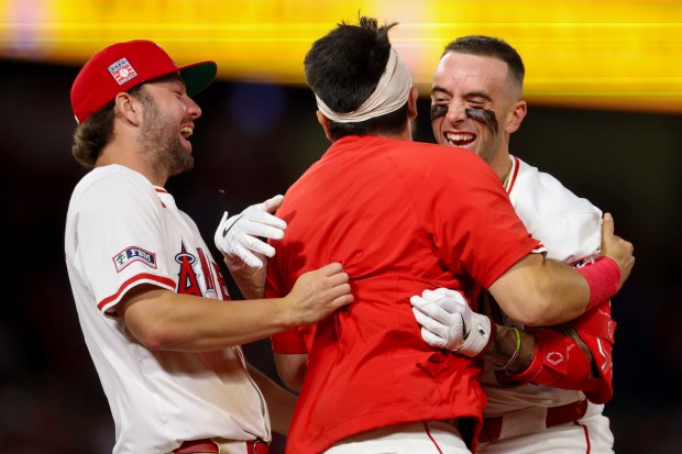 The Angels’ Zach Neto, right, celebrates with teammates Nolan Schanuel,...