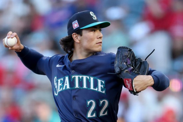 Seattle Mariners starting pitcher Bryan Woo throws to the plate...