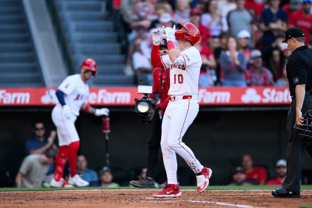 The Angels’ Kevin Newman gestures after running the bases following...