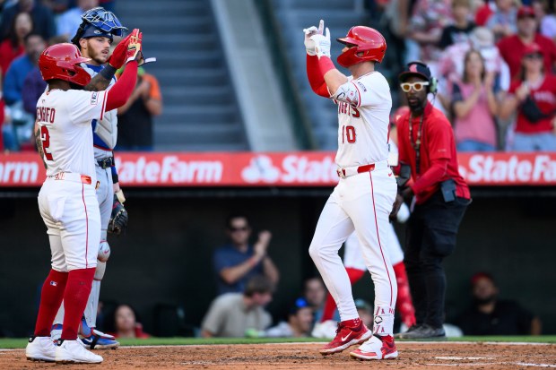 The Angels’ Kevin Newman, right, gestures as he celebrates with...