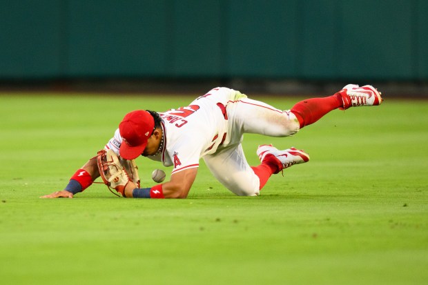 Angels right fielder Gustavo Campero makes an error while trying...