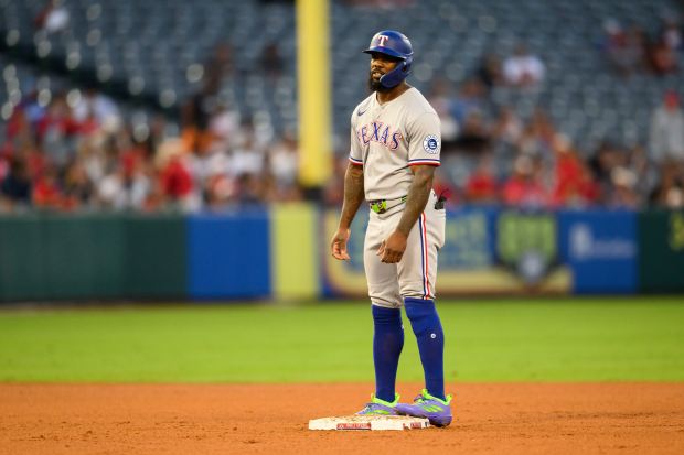 The Texas Rangers’ Adolis García reaches second base on an...