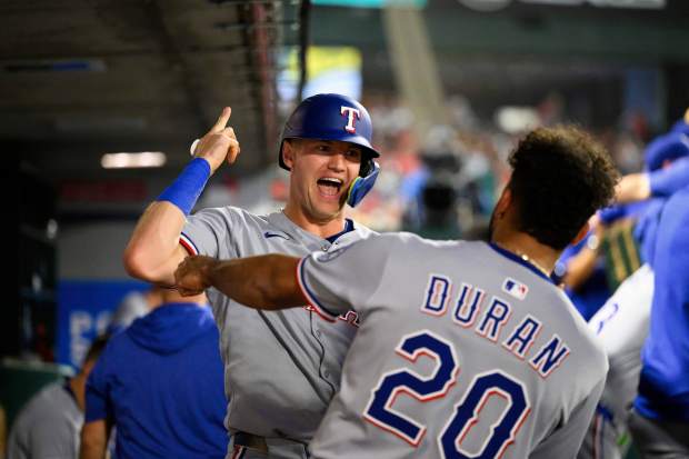 The Texas Rangers’ Josh Jung, left, celebrates with teammates in...