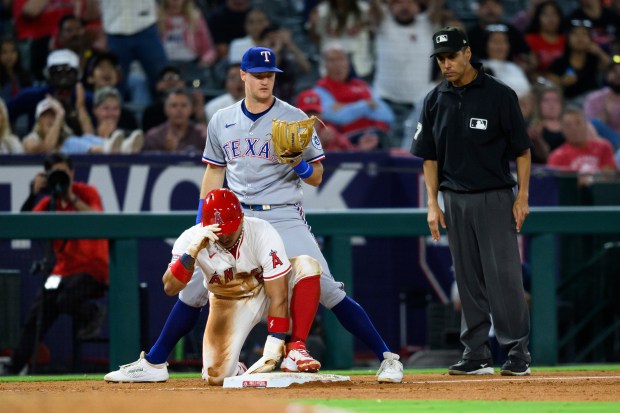 The Angels’ Gustavo Campero, bottom left, safely steals third base...