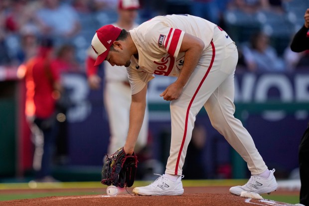 Angels starting pitcher Yusei Kikuchi picks up a baseball before...