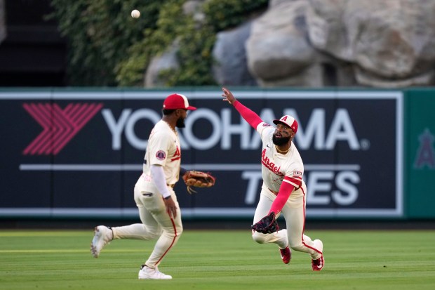 Angels center fielder Jo Adell, right, is unable to handle...