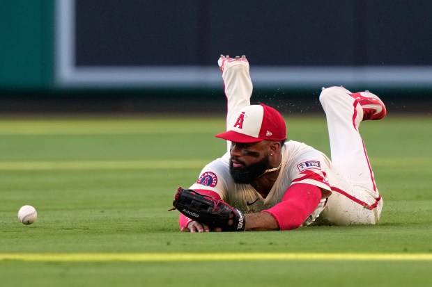 Angels center fielder Jo Adell is unable to handle a...