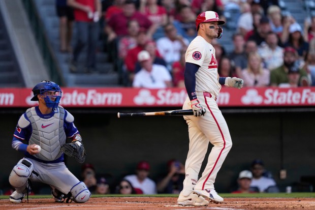 Angels star Mike Trout, right, walks away after striking out...