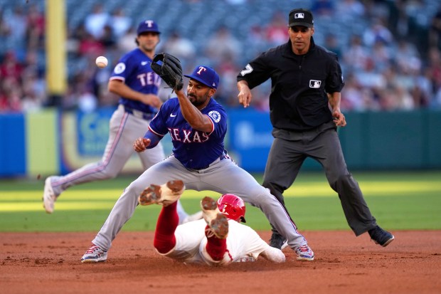 The Angels’ Zach Neto, below, steals second base as Texas...