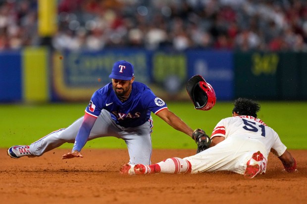 The Angels’ Gustavo Campero, right, is tagged out by Texas...