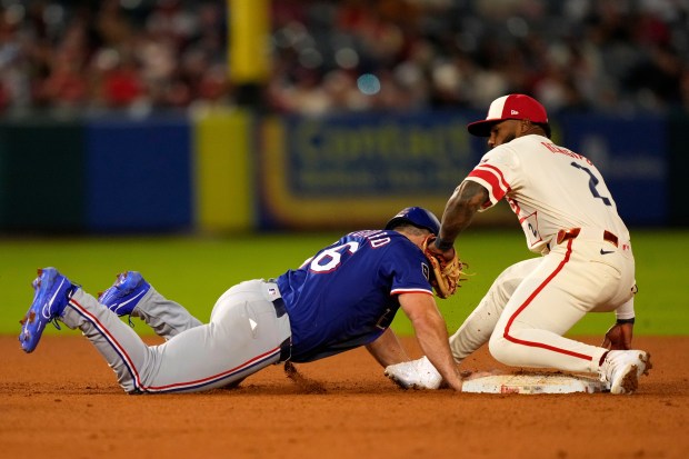 The Texas Rangers’ Wyatt Langford, left, is tagged out at...