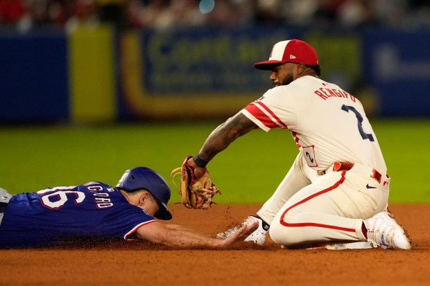 The Texas Rangers’ Wyatt Langford, left, is tagged out at...