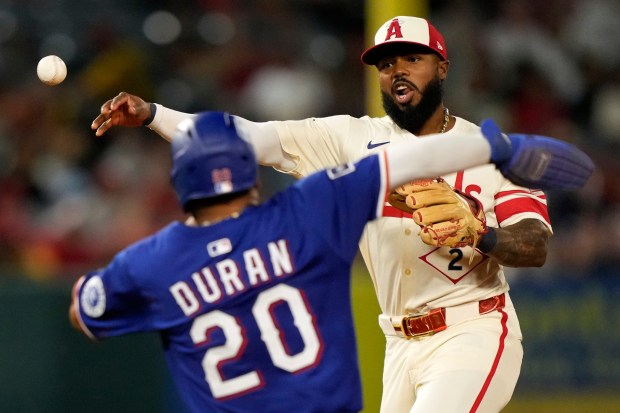 The Texas Rangers’ Ezequiel Duran, left, is forced out at...